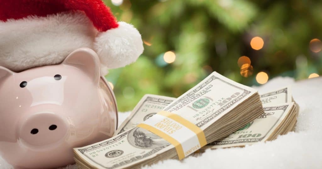 Piggy bank wearing a Santa hat with money